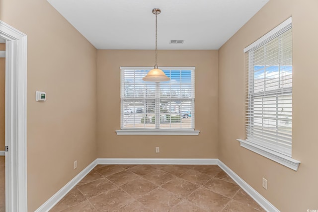 unfurnished dining area with baseboards and visible vents