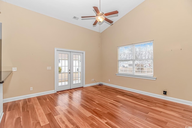 empty room featuring visible vents, baseboards, a ceiling fan, light wood-style floors, and french doors