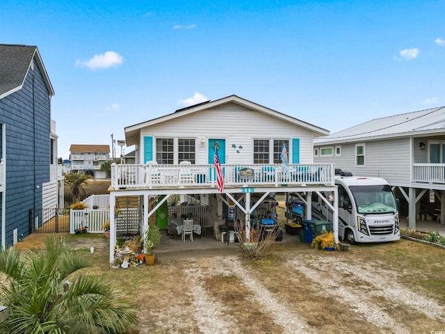rear view of property featuring a carport and dirt driveway