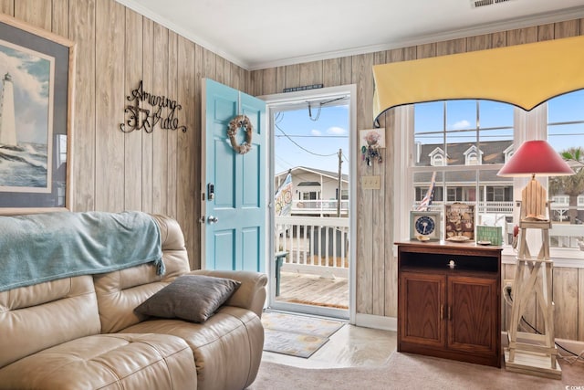 sitting room featuring ornamental molding, visible vents, and wood walls