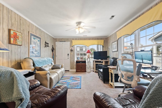 living room featuring visible vents, ceiling fan, crown molding, wood walls, and carpet flooring