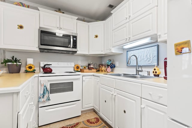 kitchen with white appliances, white cabinetry, visible vents, a sink, and light countertops