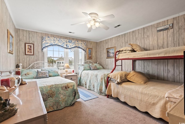 carpeted bedroom featuring crown molding, visible vents, and ceiling fan