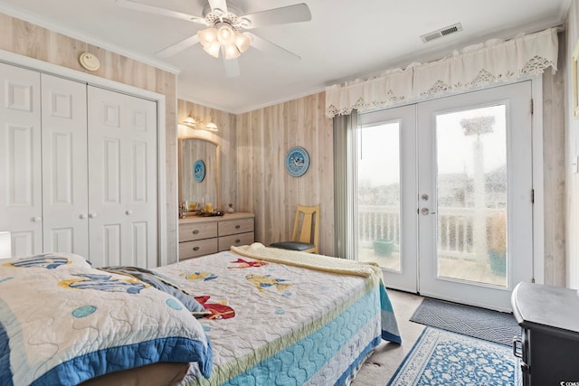 bedroom featuring a closet, visible vents, access to exterior, french doors, and wooden walls