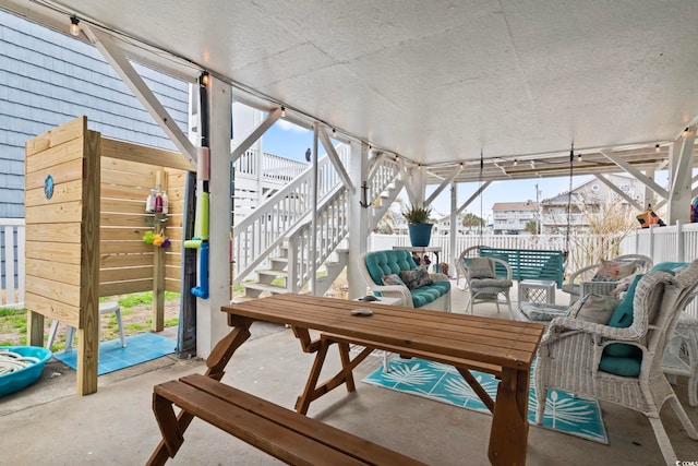 exterior space featuring an outdoor living space, fence, and stairway
