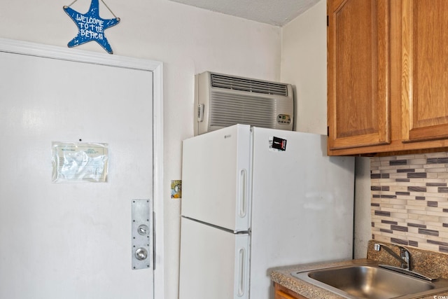 kitchen featuring tasteful backsplash, sink, a wall mounted AC, and white refrigerator