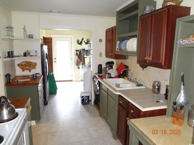 kitchen featuring sink, tasteful backsplash, tile countertops, stainless steel fridge, and white range with electric stovetop