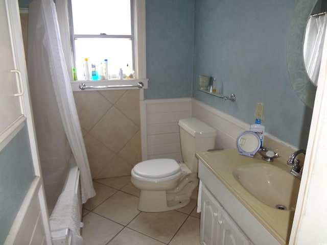 full bathroom featuring tile walls, vanity, toilet, tile patterned floors, and shower / bath combo with shower curtain