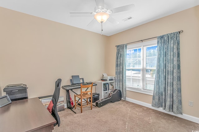 office space with light colored carpet, visible vents, ceiling fan, and baseboards