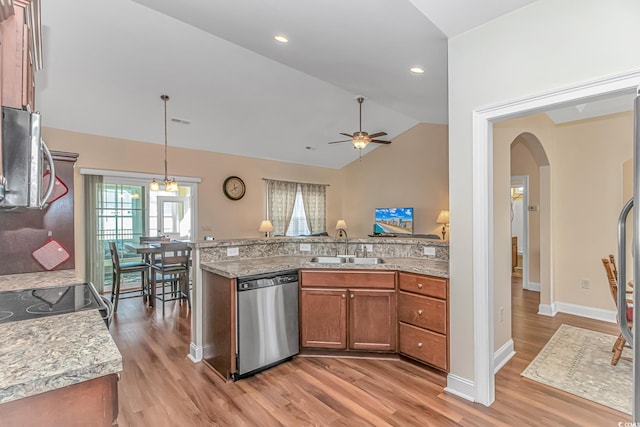 kitchen with decorative light fixtures, appliances with stainless steel finishes, brown cabinetry, vaulted ceiling, and a sink