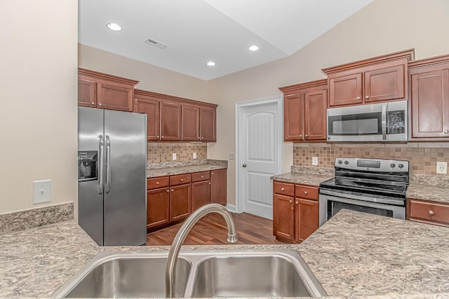 kitchen featuring stainless steel appliances, light countertops, a sink, and visible vents