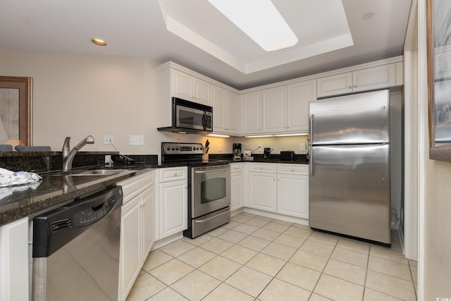 9994 Beach Club Dr Unit 1601, Myrtle Beach, SC 29572 - kitchen featuring appliances with stainless steel finishes, a raised ceiling, light tile patterned floors, white cabinets, and a sink