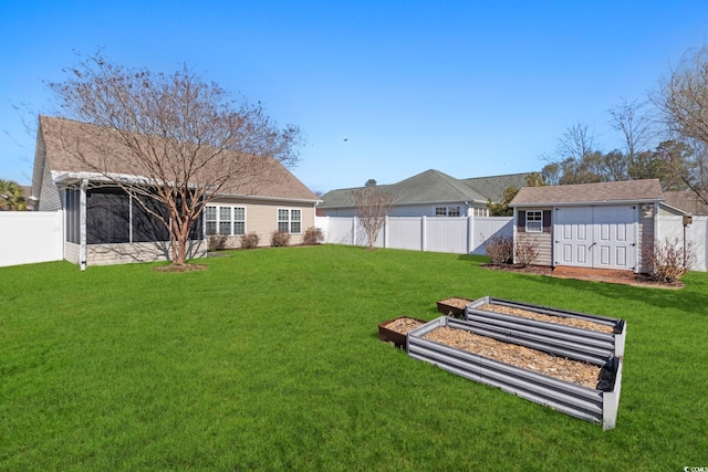 view of yard with a sunroom, a shed, a fenced backyard, and an outbuilding