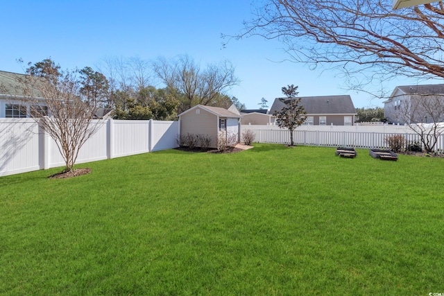 view of yard with an outbuilding, a fenced backyard, and a storage shed