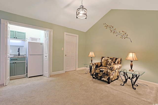 living area with lofted ceiling, sink, and light colored carpet