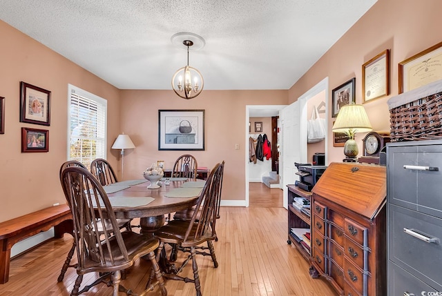 1800 Glenns Bay Rd, Surfside Beach, SC 29575 - dining space featuring an inviting chandelier, light hardwood / wood-style flooring, and a textured ceiling
