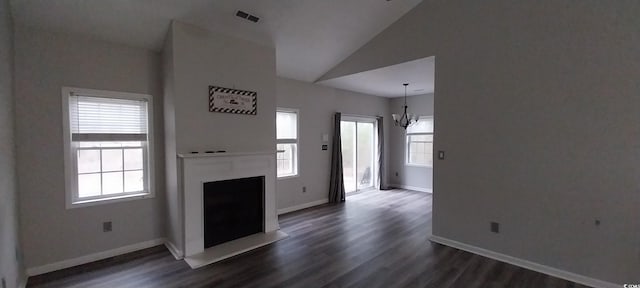 unfurnished living room with dark hardwood / wood-style flooring, vaulted ceiling, and a notable chandelier