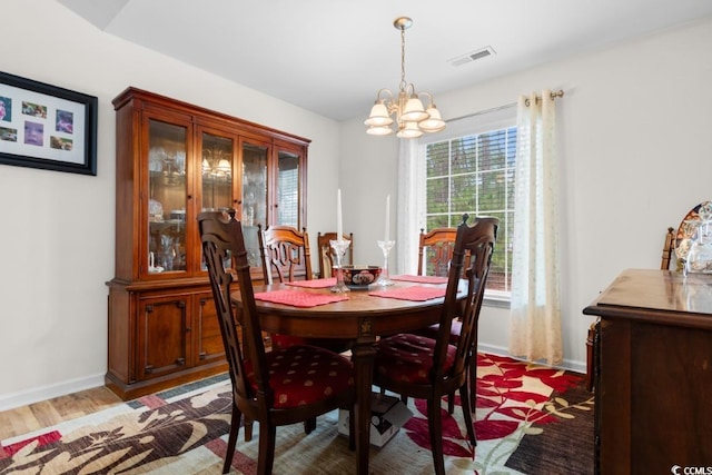 dining room featuring an inviting chandelier and light wood-type flooring