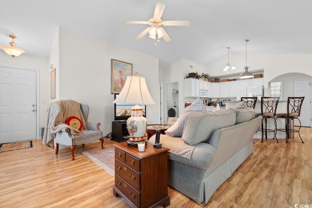 living room featuring vaulted ceiling, ceiling fan, washer / dryer, and light hardwood / wood-style floors