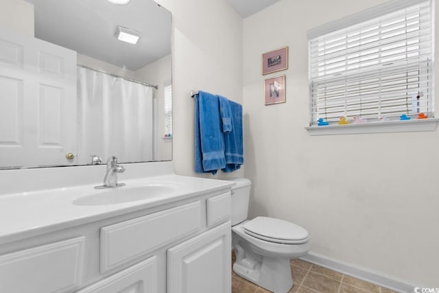 bathroom featuring vanity, plenty of natural light, tile patterned floors, and toilet