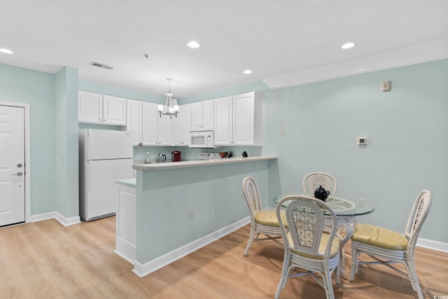 395 S Crow Creek Dr Unit 1418, Calabash, NC 28467 - kitchen featuring white appliances, white cabinets, recessed lighting, a peninsula, and light wood finished floors