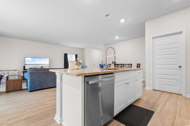 242 Timber Oaks Dr, Myrtle Beach, SC 29588 - kitchen with stainless steel dishwasher, a sink, light wood-style floors, white cabinetry, and light stone countertops