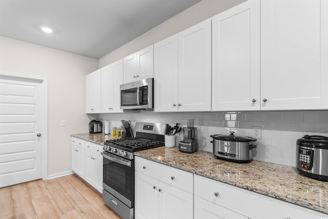 242 Timber Oaks Dr, Myrtle Beach, SC 29588 - kitchen with appliances with stainless steel finishes, tasteful backsplash, white cabinetry, and light stone counters