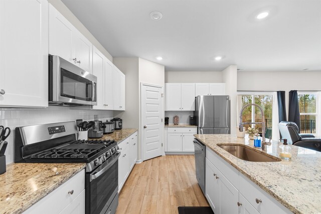 242 Timber Oaks Dr, Myrtle Beach, SC 29588 - kitchen with stainless steel appliances, white cabinets, light wood-style flooring, backsplash, and recessed lighting