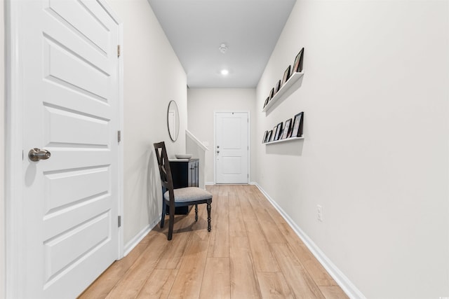 hall featuring light wood finished floors and baseboards