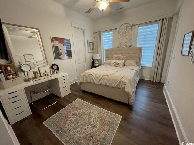 bedroom featuring built in desk, dark hardwood / wood-style floors, and ceiling fan