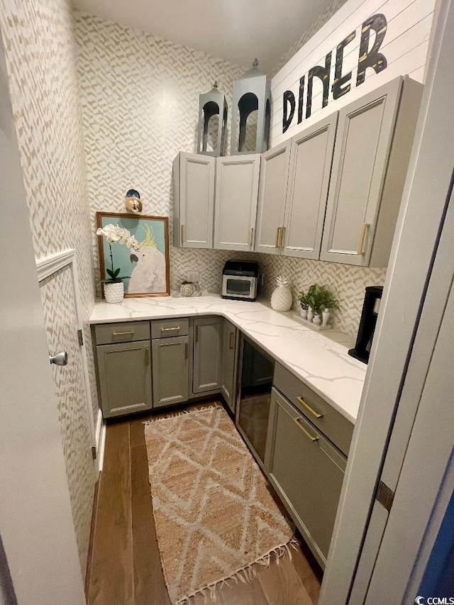 kitchen featuring light stone countertops, dark hardwood / wood-style floors, and decorative backsplash