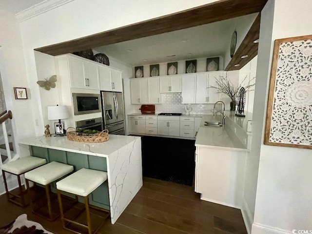 kitchen featuring sink, stainless steel appliances, kitchen peninsula, and white cabinets