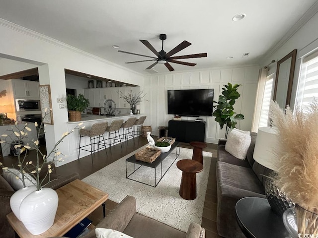 living room with ceiling fan, ornamental molding, and dark hardwood / wood-style flooring