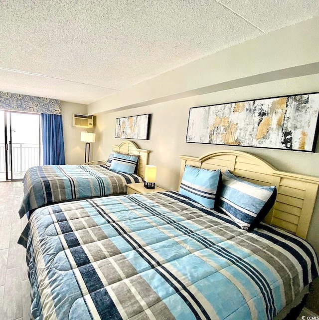 bedroom with a wall mounted air conditioner and a textured ceiling