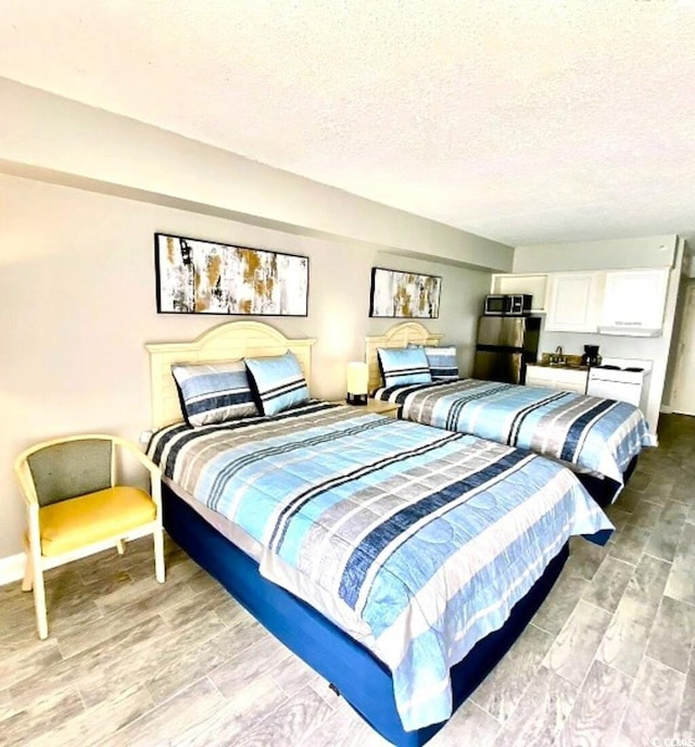 bedroom featuring a textured ceiling and light wood-type flooring