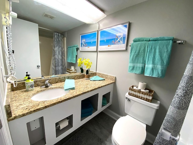 bathroom featuring vanity, hardwood / wood-style floors, curtained shower, and toilet