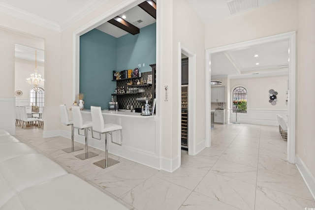 bar with crown molding, pendant lighting, and an inviting chandelier