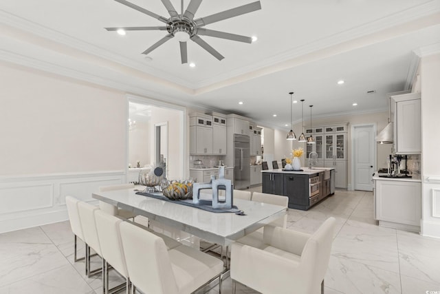 dining area featuring crown molding, ceiling fan, and sink