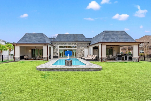 rear view of property featuring a fenced in pool, a patio, a yard, and ceiling fan