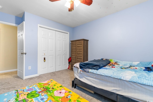 bedroom featuring light colored carpet, ceiling fan, and a closet