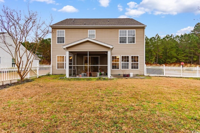 back of property with a patio area, a sunroom, and a lawn