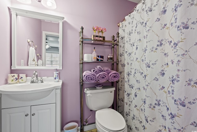 bathroom featuring vanity, curtained shower, and toilet