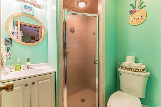 full bath featuring a stall shower, vanity, and toilet