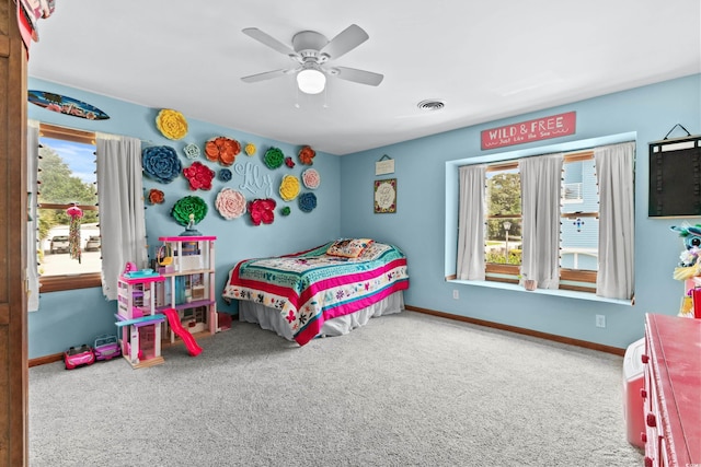 carpeted bedroom featuring visible vents, baseboards, and multiple windows