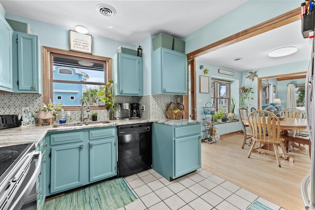 kitchen featuring a sink, visible vents, black dishwasher, electric stove, and decorative backsplash