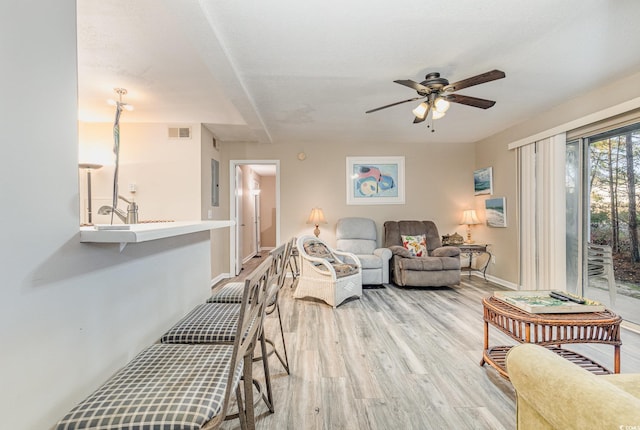 living room featuring a textured ceiling, light hardwood / wood-style floors, and ceiling fan