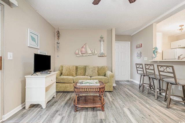 living room featuring ceiling fan and light hardwood / wood-style floors