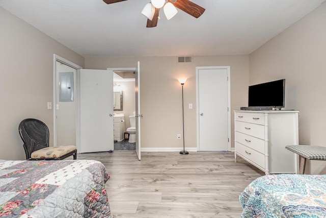 bedroom featuring ceiling fan, connected bathroom, electric panel, and light wood-type flooring