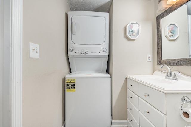 clothes washing area featuring stacked washer / dryer and sink