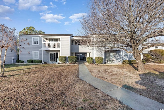 view of front facade featuring a balcony and a front lawn